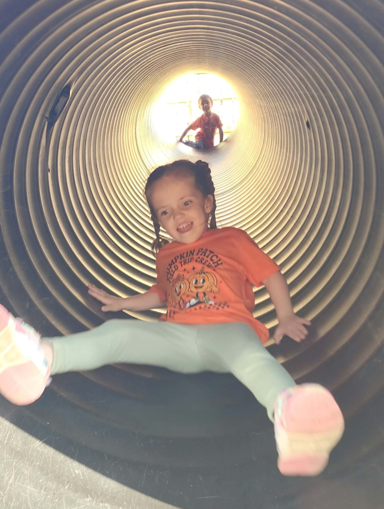A student is sliding down a tube slide. 