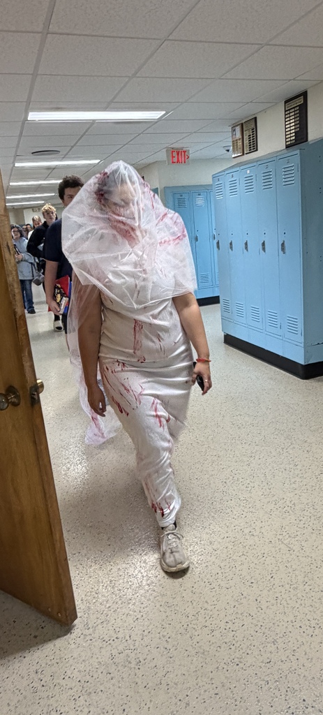 A student is dressed in white with red splattered all over. 