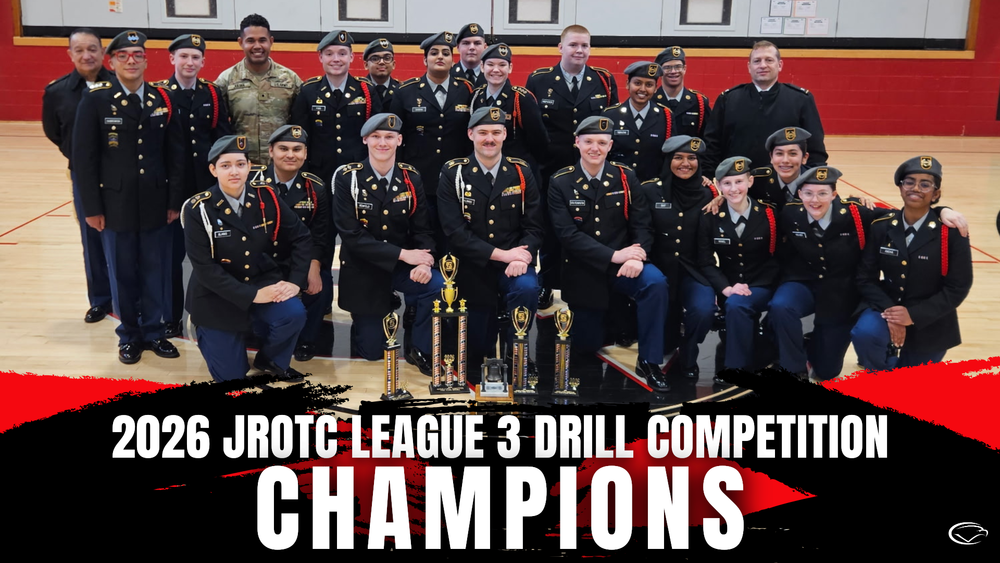 JROTC team in dress uniforms posing in a gym with multiple trophies and a banner reading ‘2026 JROTC League 3 Drill Competition Champions.