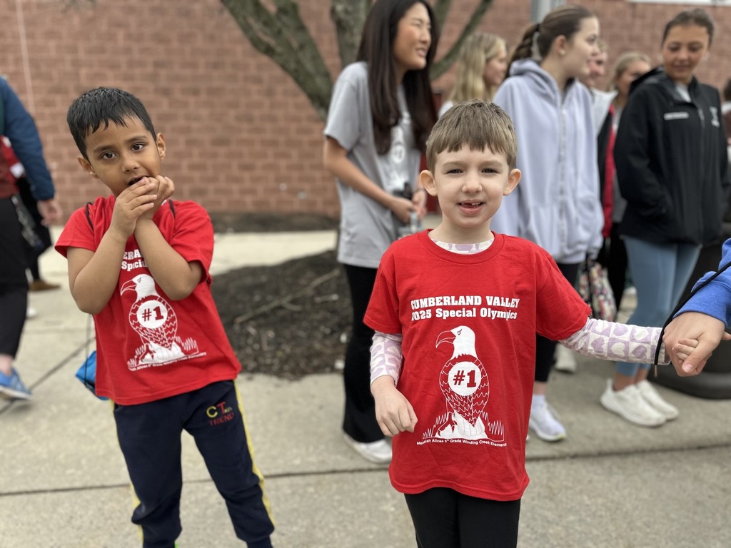Two student-athletes in red shirts smile during the Special Olympics event.