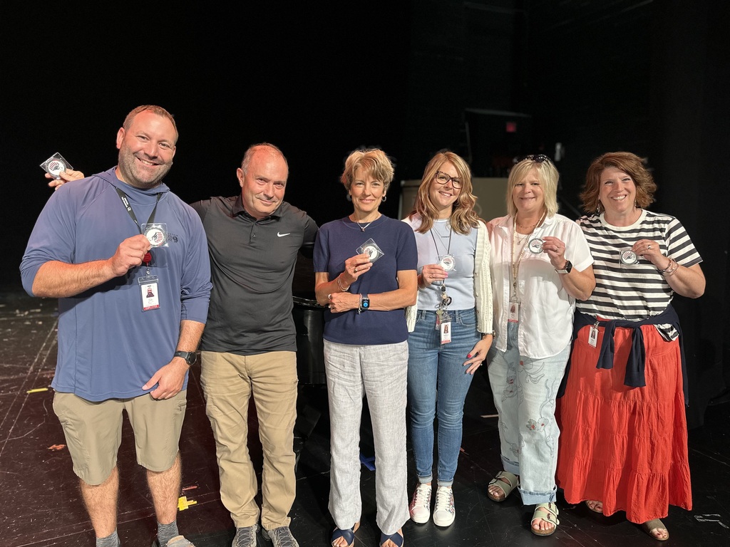 Six people on stage holding POE coins, recognized for their commitment to the CV community.