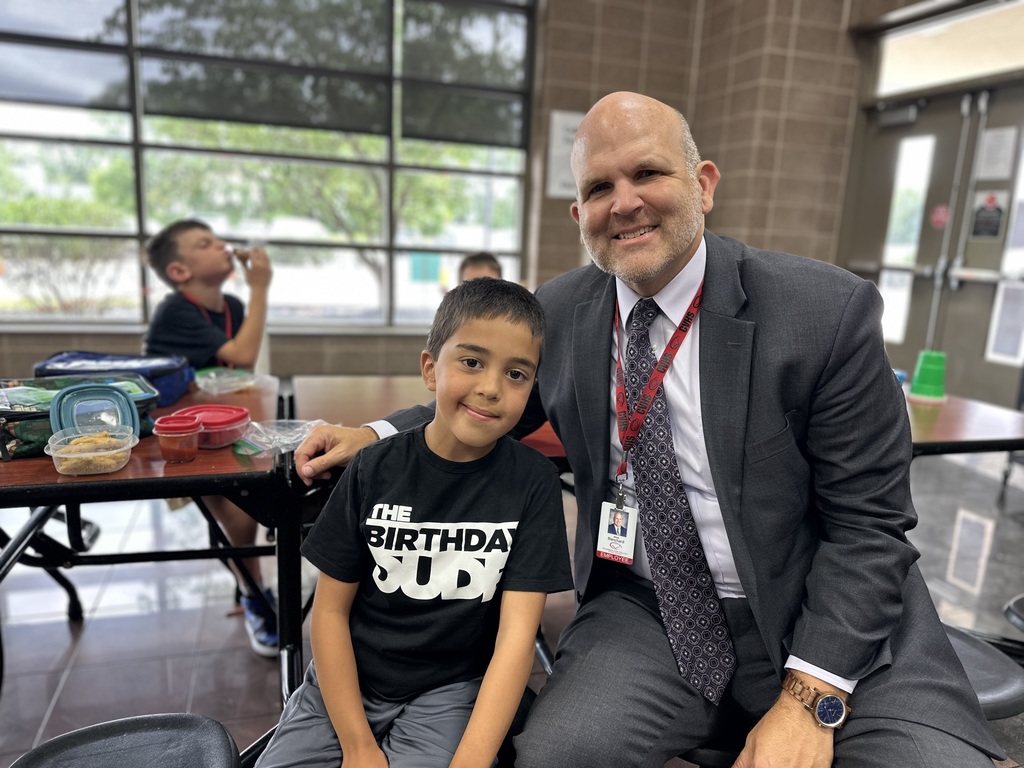 CV Superintendent seated at a table with students during lunch.