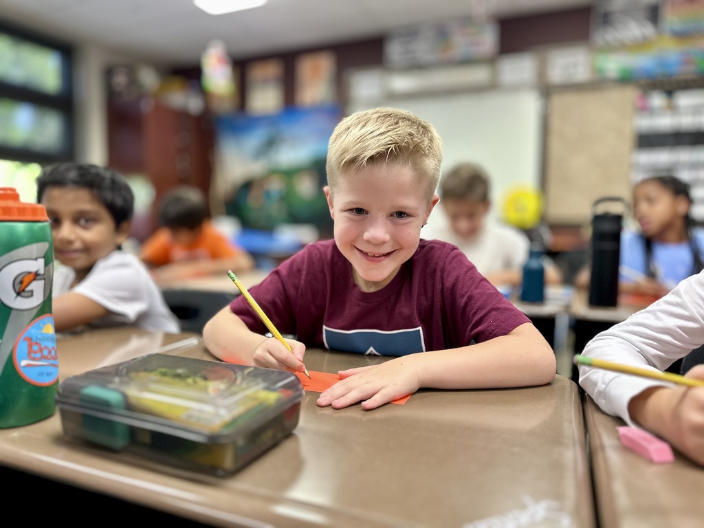 Children working at desks in a classroom during the Star Lab Planetarium activity.