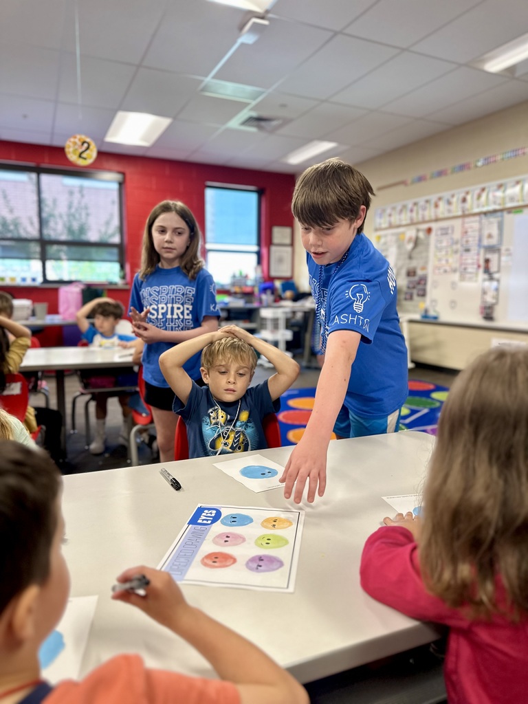 Children in a classroom working together on a colorful paper activity.