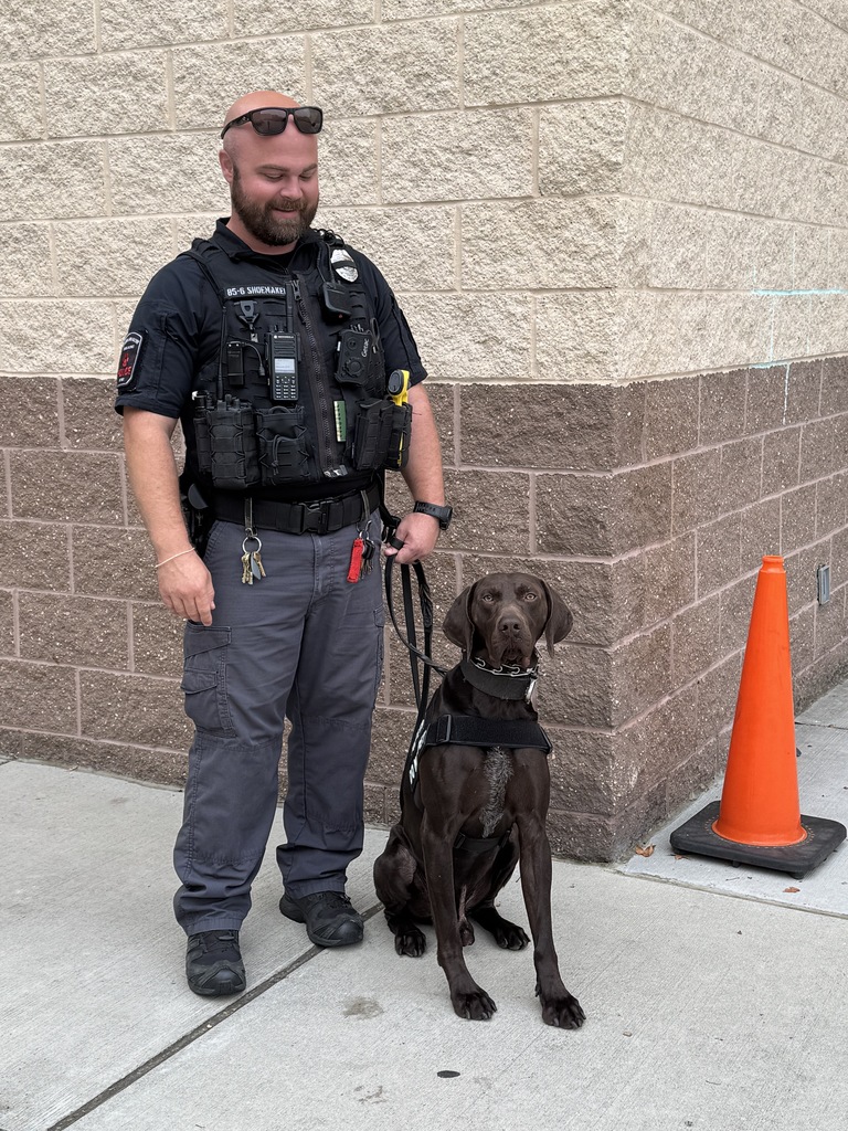 CVSD Officer Shoemake stands with K-9 dog, Zoro outside of Middlesex Elementary School.