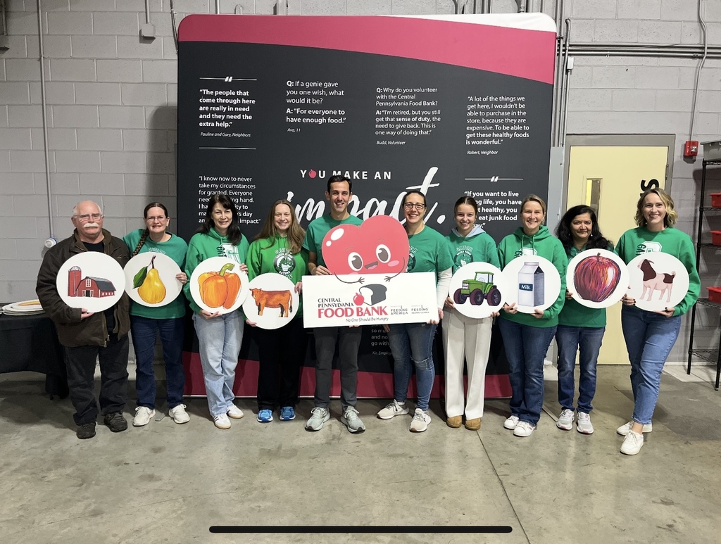 Green Ridge Elementary staff hold various food signs at the Central PA Food Bank distribution center.