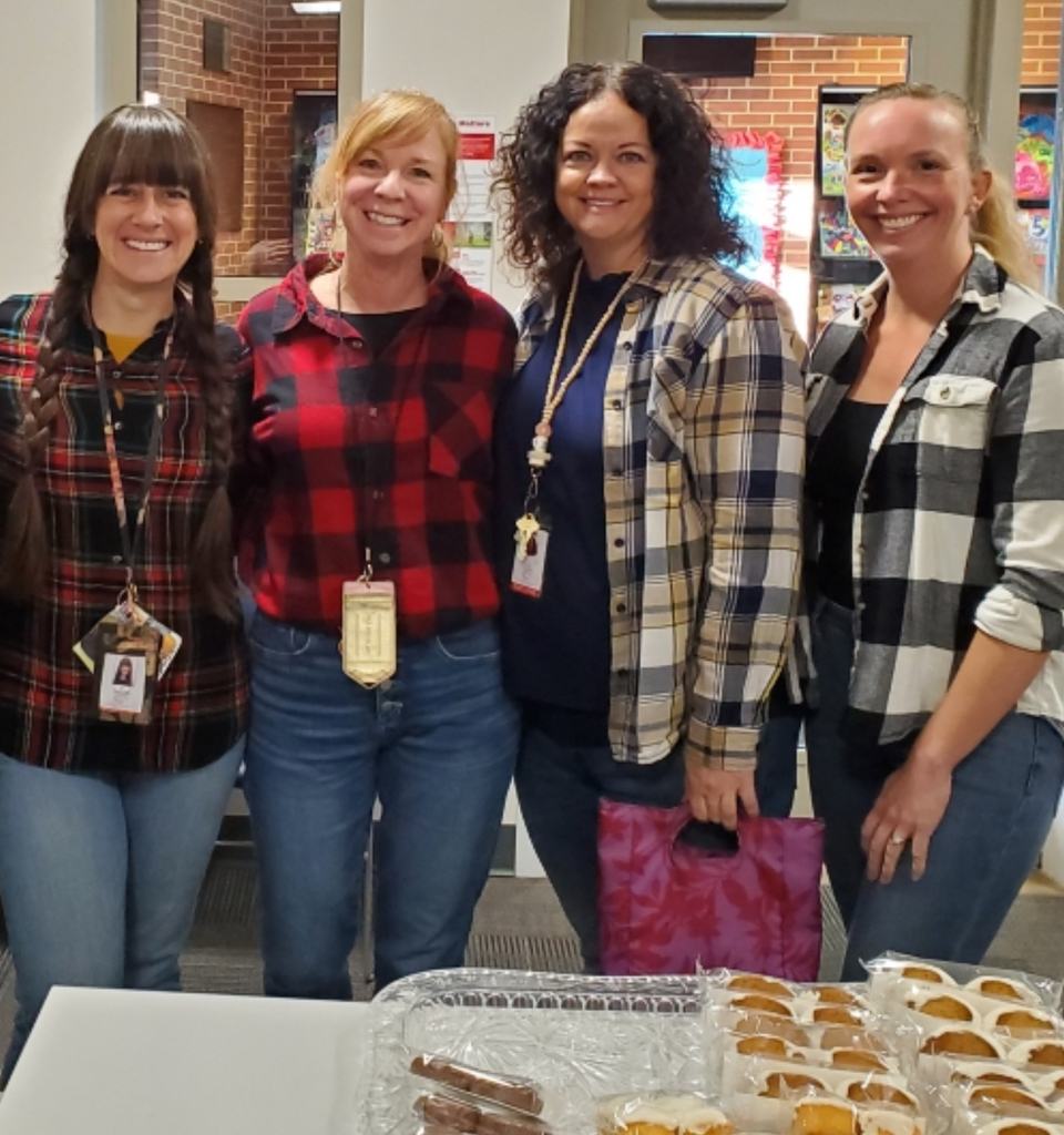 Group of four female teachers wearing plaid shirts