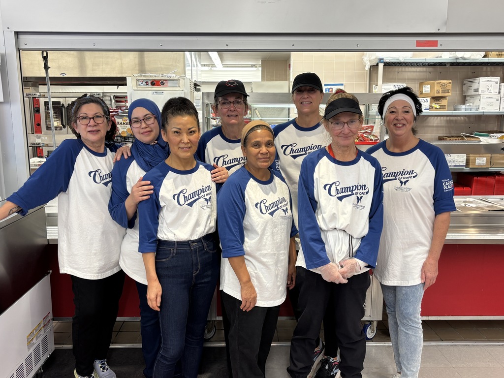 CV9 kitchen staff standing together wearing matching blue ‘Champion of Hope’ T-shirts in support of Children’s Grief Awareness Day. 