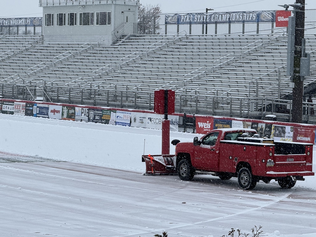 Red utility truck plows the snow off of Chapman field at Cumberland Valley School District.