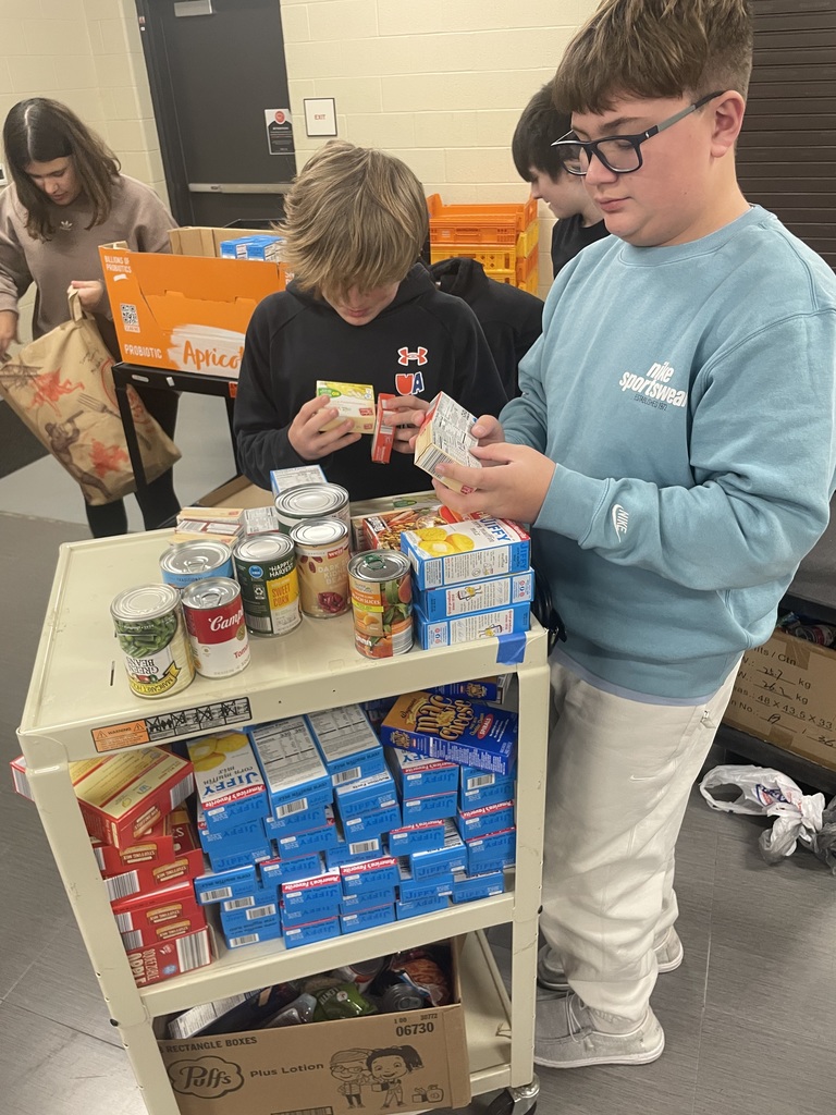 Students sorting canned goods and boxed food items on a cart during Mountain View Middle School’s canned food drive.