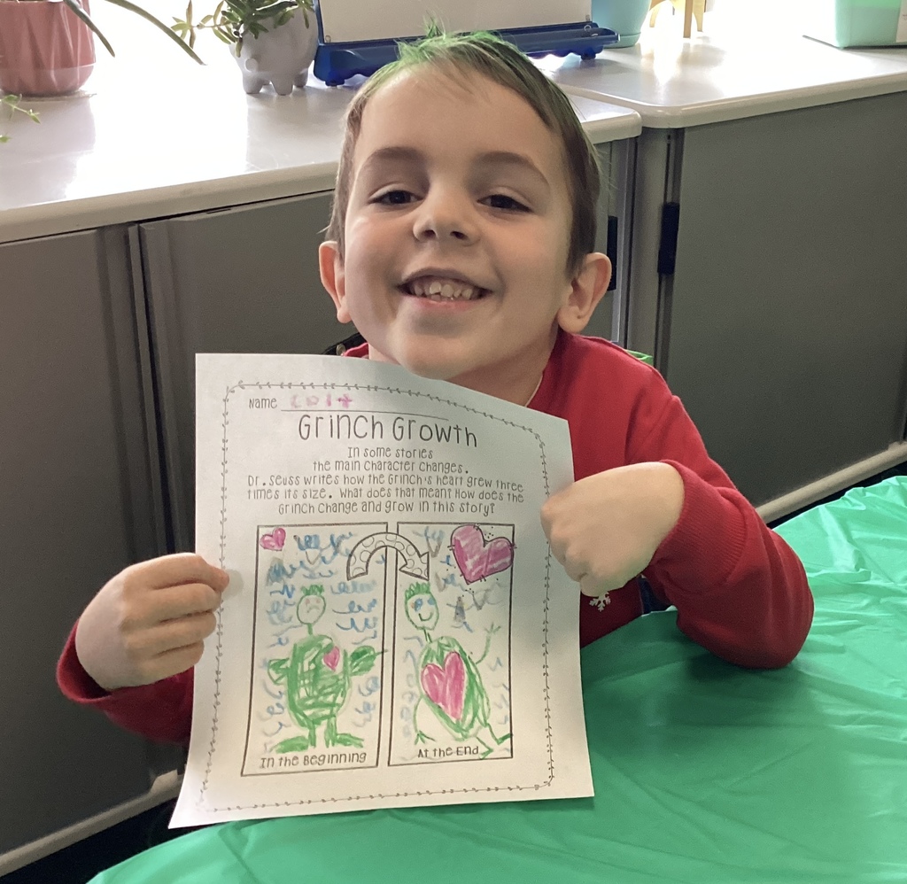 Kindergarten student holding a Grinch-themed worksheet titled ‘Grinch Growth’ during Middlesex Elementary’s Grinch Day.