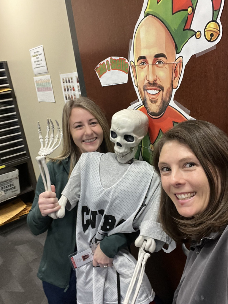 Staff members at Mountain View Middle School take a selfie with Snelfie and a dressed-up skeleton figure.