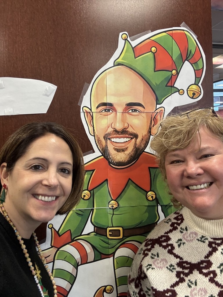 Mountain View Middle School administrators take a selfie in front of a festive cardboard elf named Snelfie.