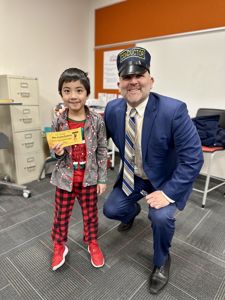 Superintendent Blanchard, dressed as a Conductor, poses with a Middlesex Elementary student who is holding a golden ticket during their Polar Express Day.