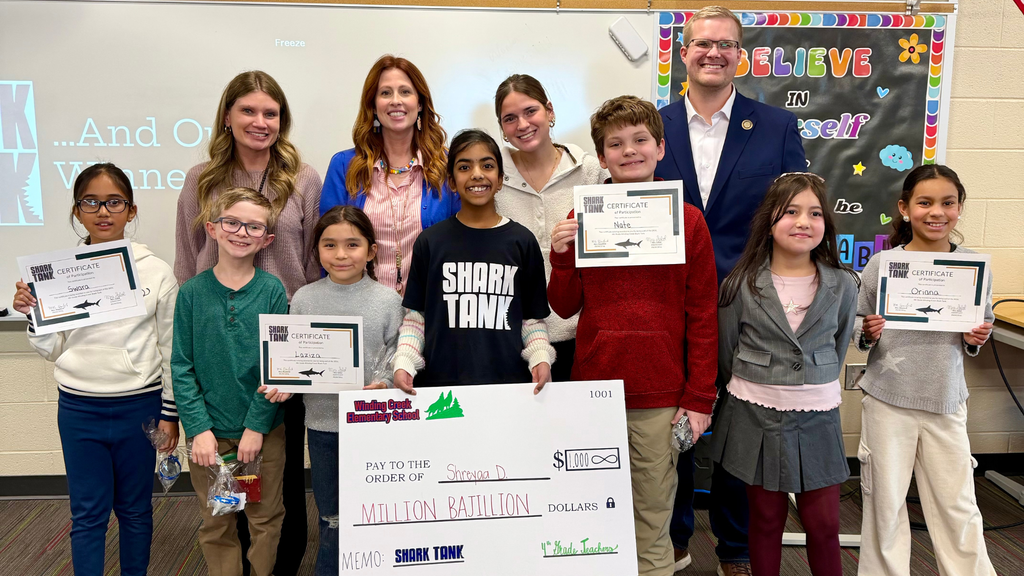 Group of Winding Creek Elementary fourth grade students pose with Sharks during their Shark Tank presentations.