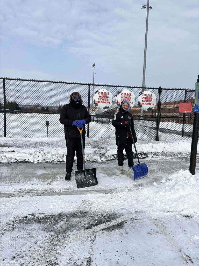 CVSD Maintenance and Facilities crews clearing off sidewalks on campus with shovels.