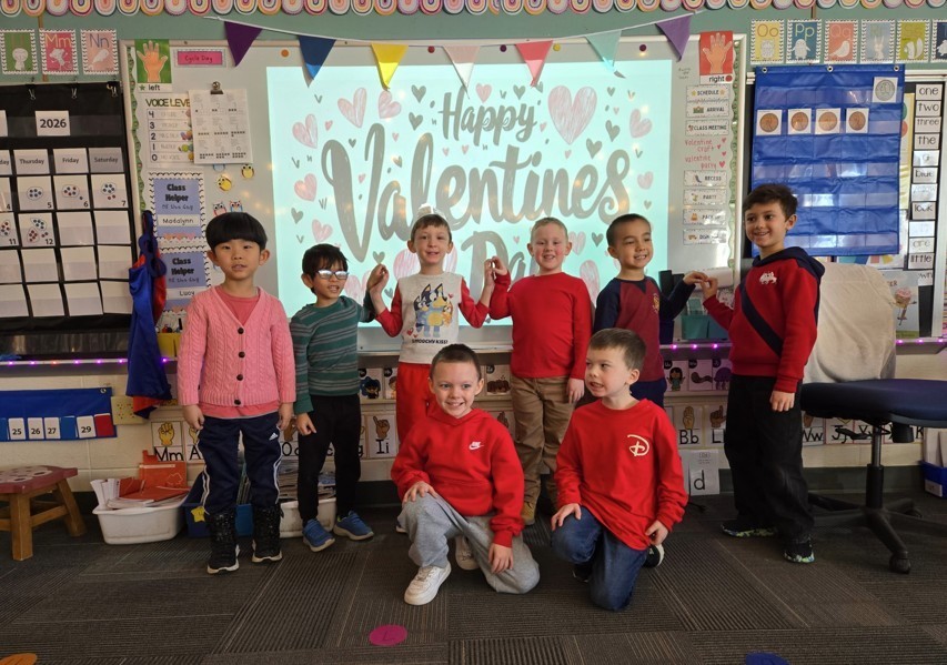 Elementary school boys standing together and smiling for class Valentine's party.