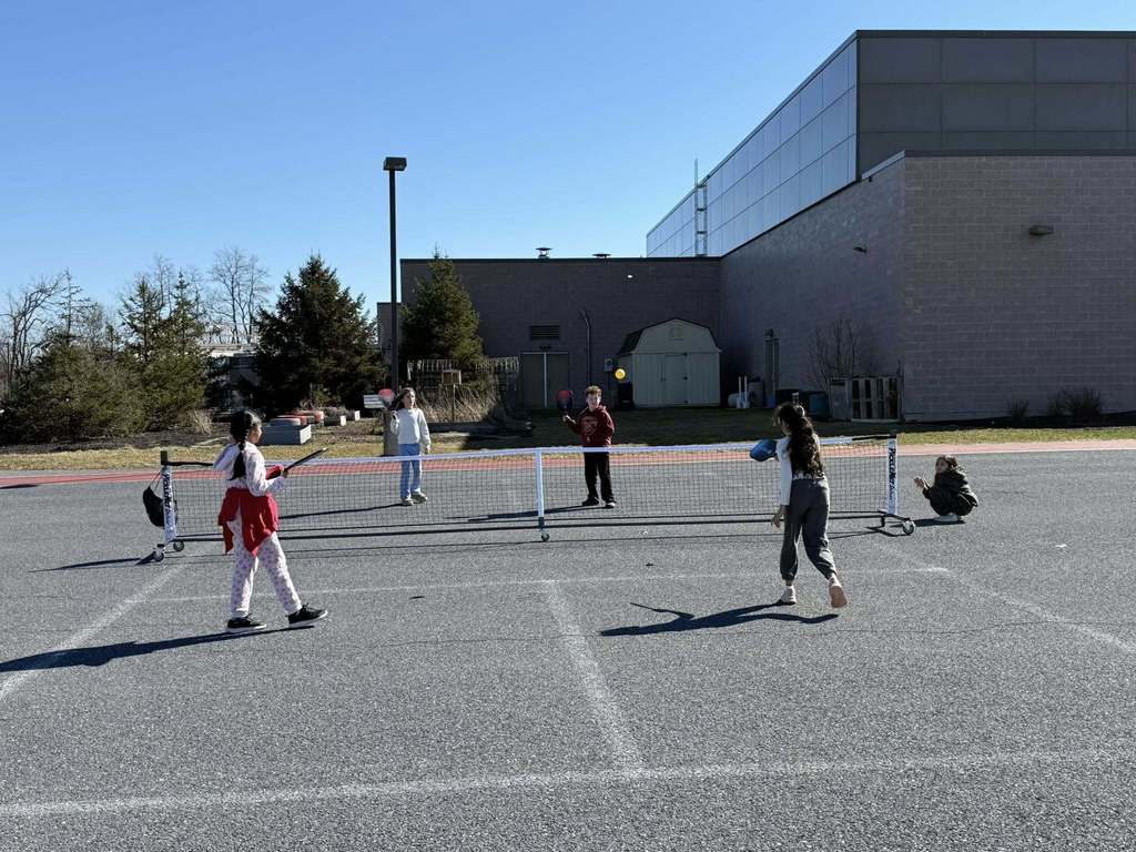 Elementary students playing pickle ball during recess.