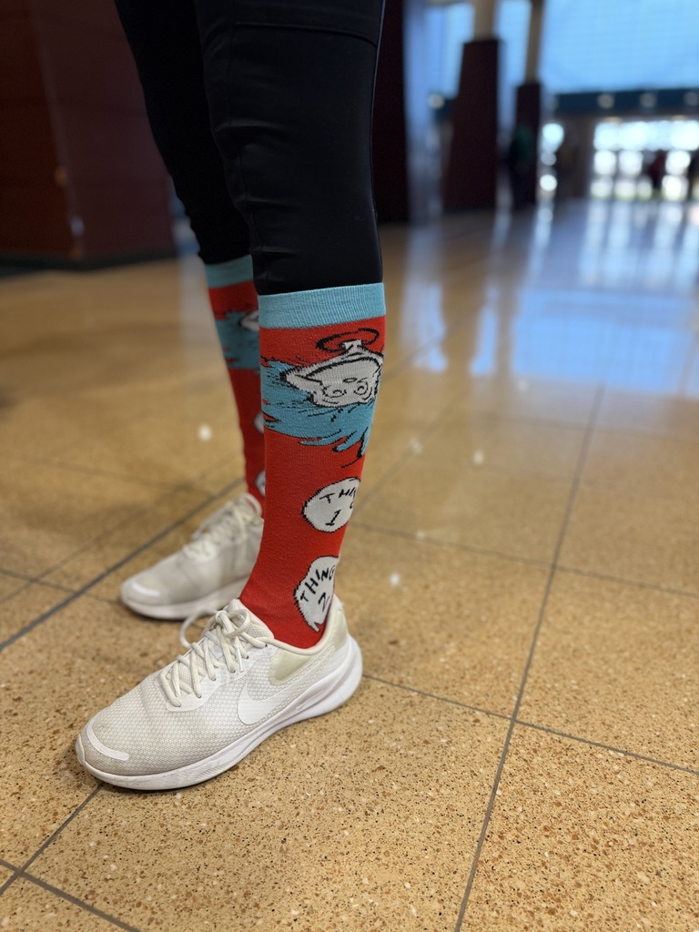A picture of a staff showing off their Thing 1 and Thing 2 socks for World Down Syndrome Day.
