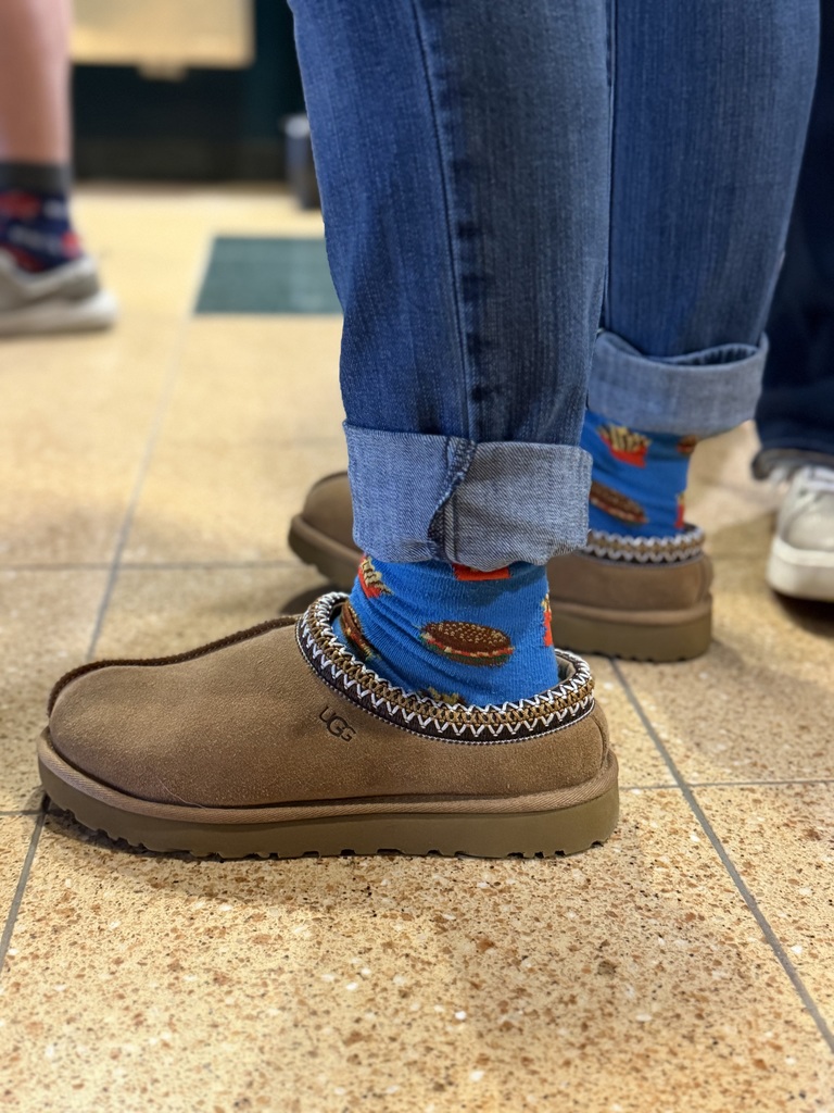 A picture of a staff showing off their cheeseburger socks for World Down Syndrome Day.