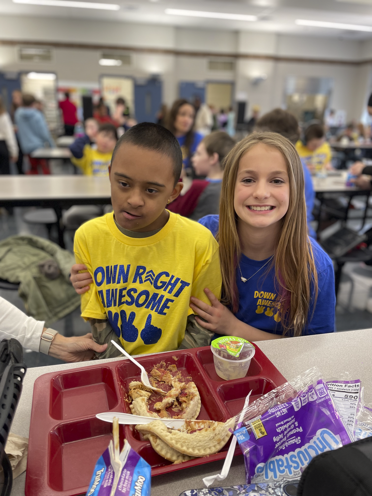 Two students pose for a picture in the cafeteria during lunch time.