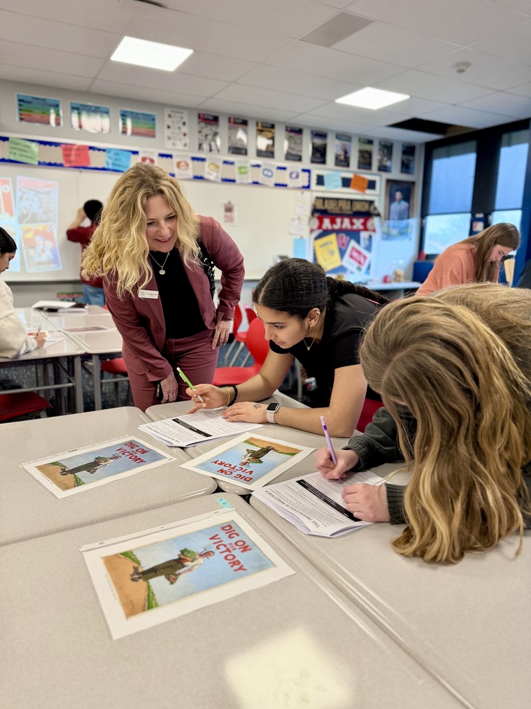 A Swedish Administrator talks with students as they are working on a history assignment.