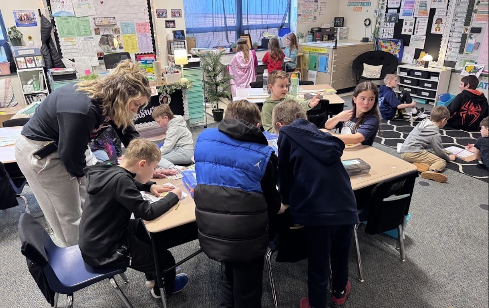 Teacher with students working on papers