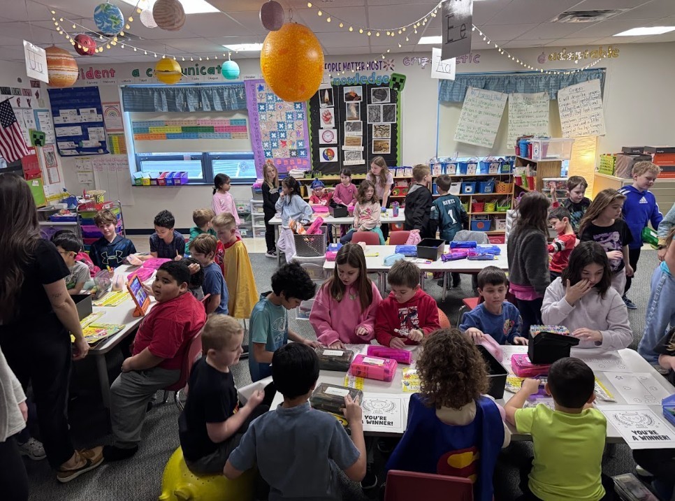 Classroom of kids working on encouraging papers