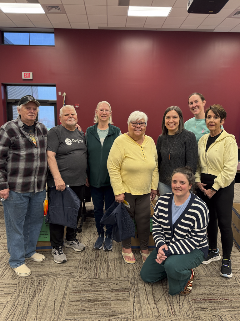 A group of eight volunteers pose for a picture after they prepared items for CV's Special Olympics.