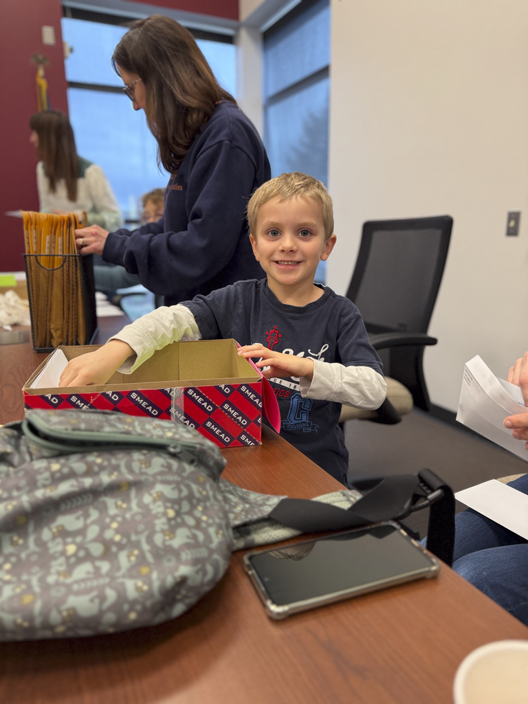 A little boy smiles as he is helping prepare items for CV's Special Olympics.