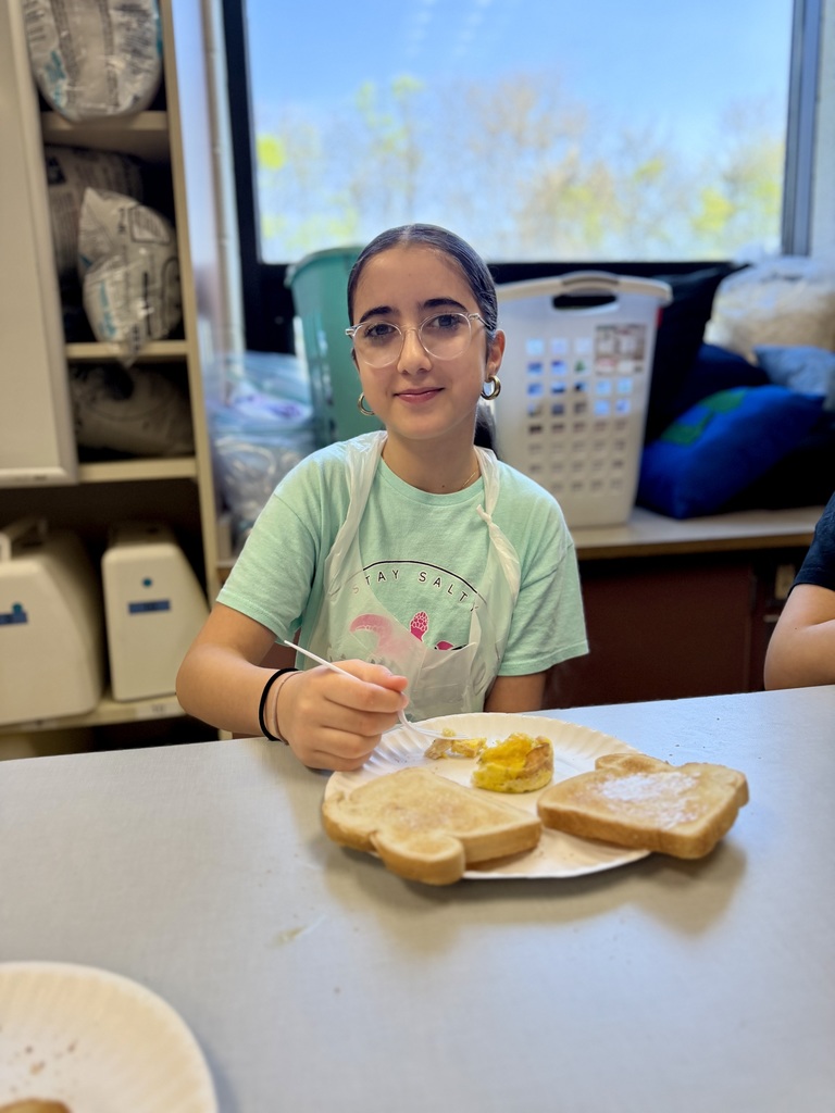 Eagle View 7th grade student enjoys her Jiffy Breakfast at a table.