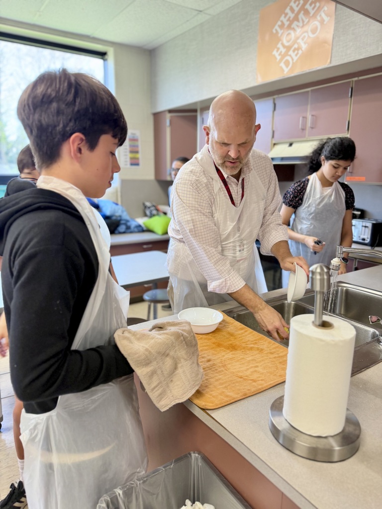 7th grade students wash dishes with Dr. Blanchard during an FCS cooking class.