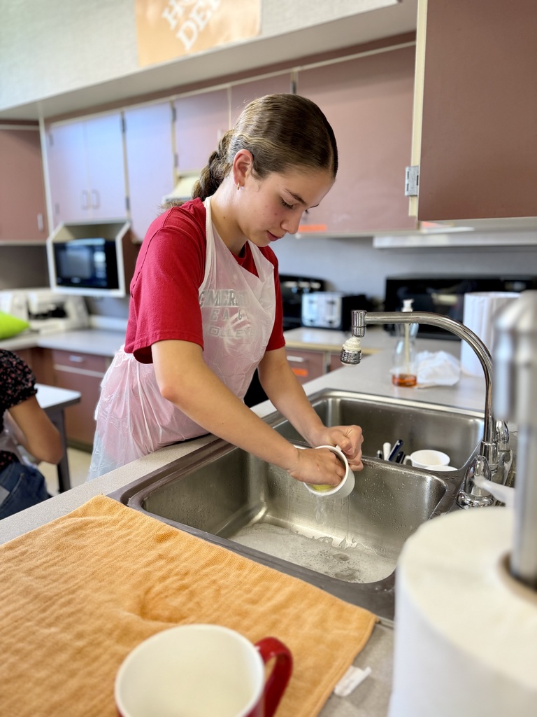 An Eagle View 7th grade student washes dishes from their Jiffy Breakfast lab.