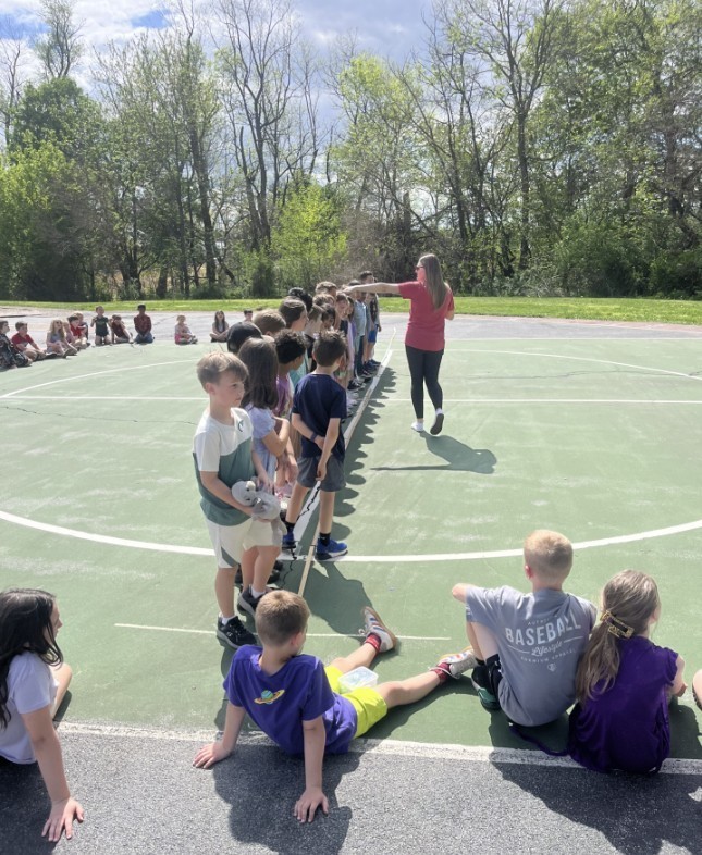 Students standing in a line being measured.