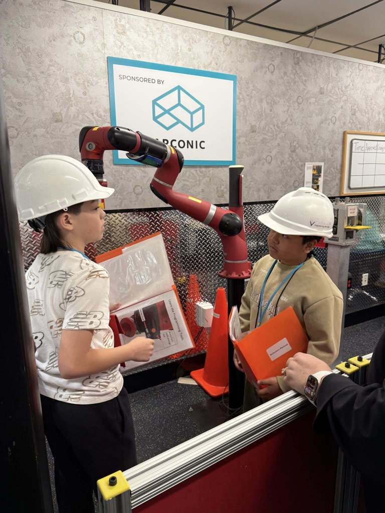 Fifth grade students wear hard hats and learn about robotics during a JA BizTown visit.