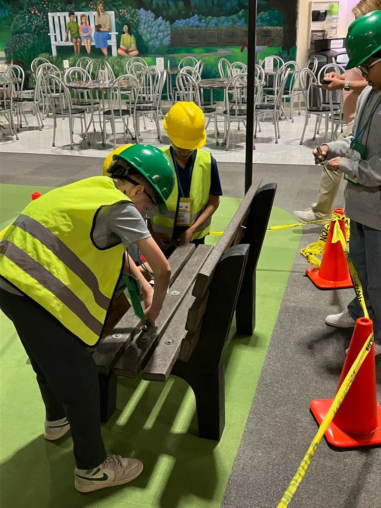 Fifth grade students wear safety vests and hard hats while working on a construction activity during a JA BizTown visit.