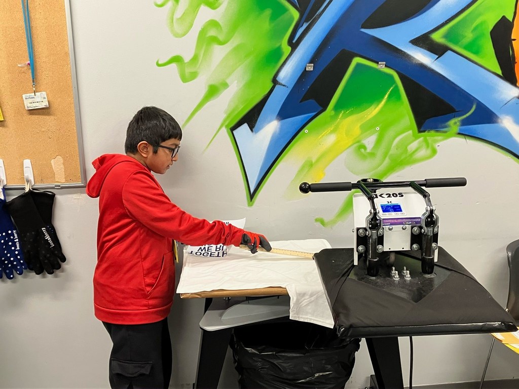 Fifth grade student measures and prepares a T-shirt at a printing station during a JA BizTown visit.