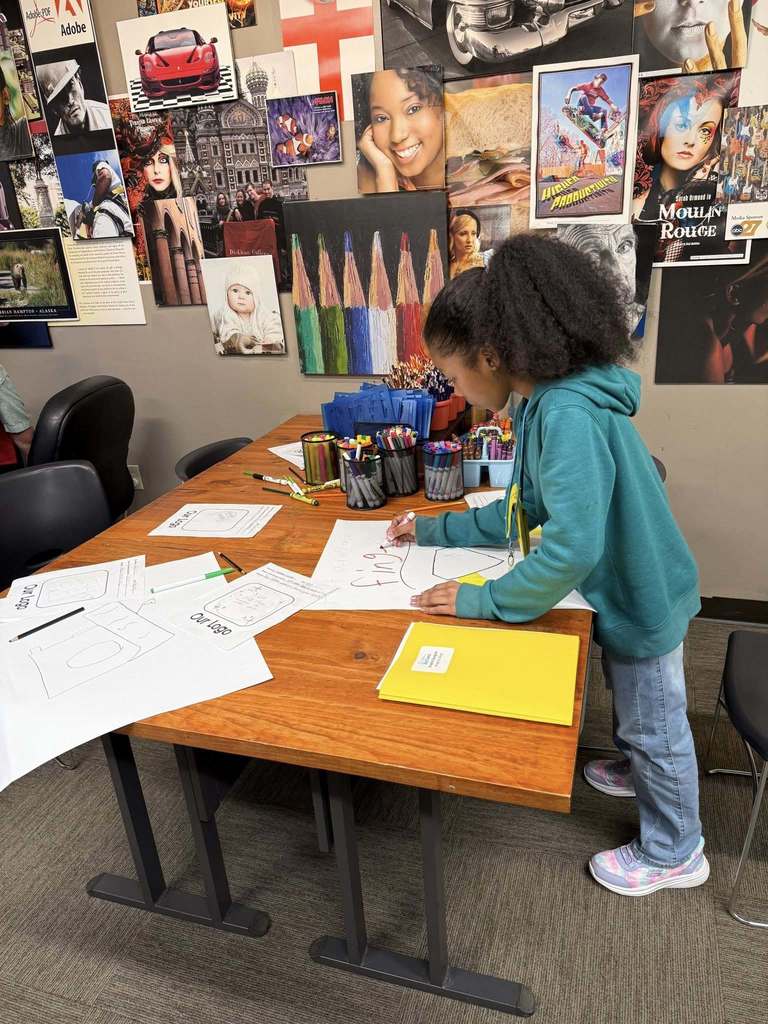Fifth grade student designs a logo at an art station during a JA BizTown visit.