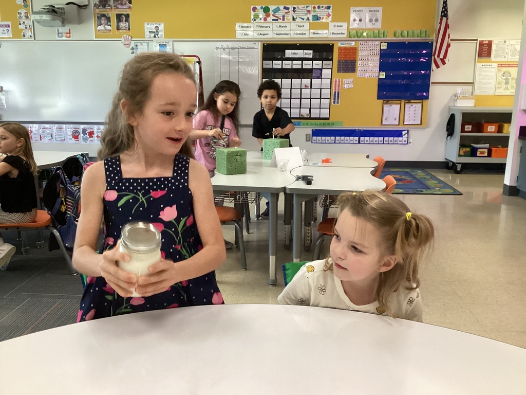 Kindergarten students help mix butter during a Colonial Towns classroom activity.