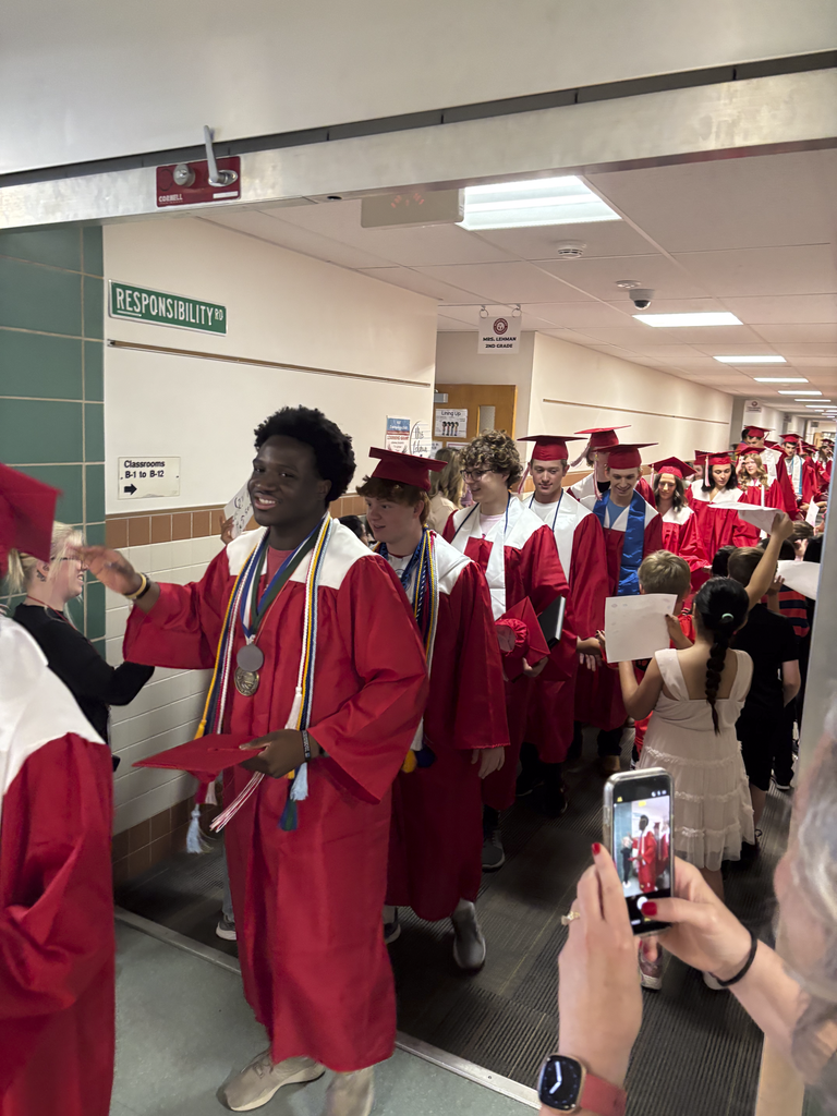 Students walk the halls of their old elementary school in their graduation caps and gowns during a Senior Walk.