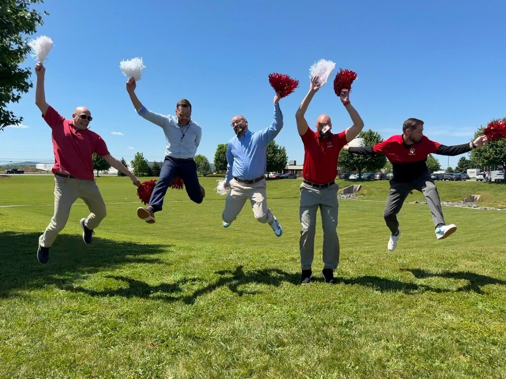 District Office staff jump in the air during the last day of school.