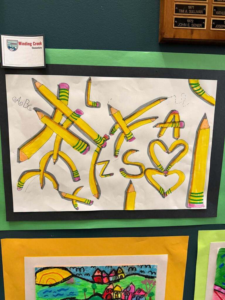 Winding Creek Elementary student artwork showing yellow pencils bent into shapes and letters, displayed on a wall .