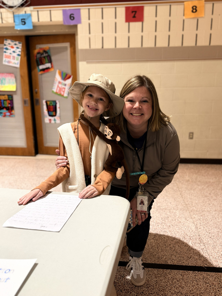 A Monroe Elementary second-grader dressed as Jane Goodall poses with a teacher beside the student's Wax Museum exhibit.