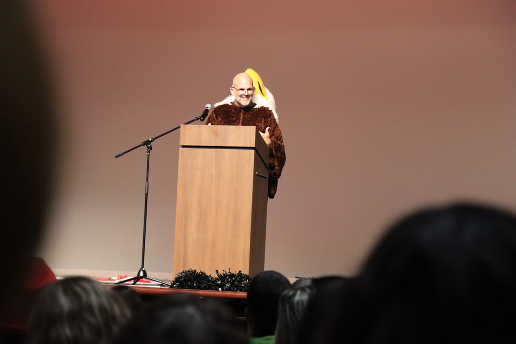 Dr. Blanchard, Superintendent, speaks to district staff from the stage in an eagle costume during the 2026-27 Convocation.