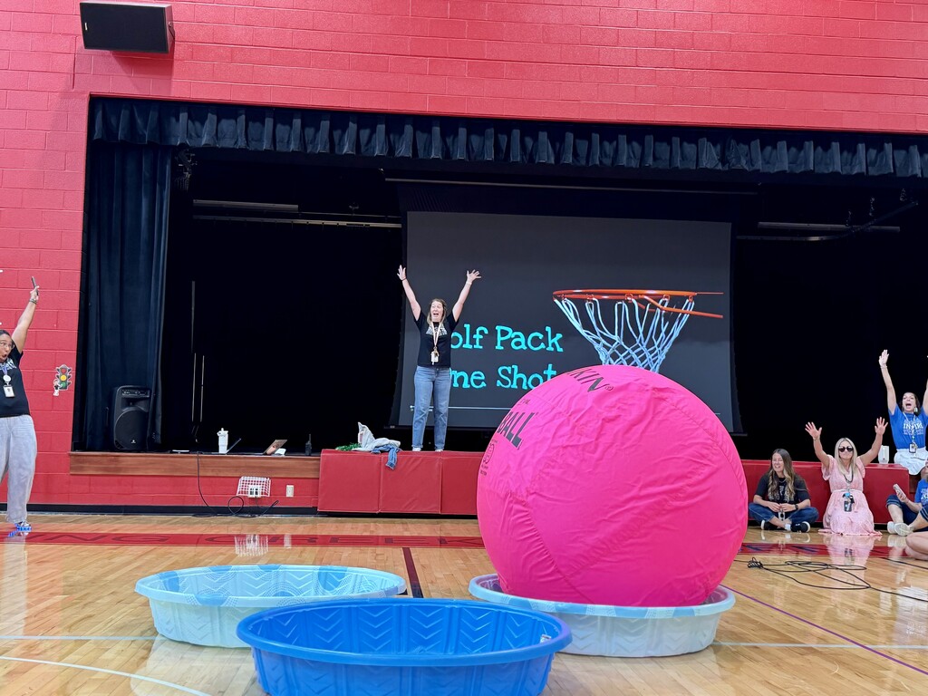A large pink ball lands in a baby pool during a House Assembly game as staff and students celebrate at Winding Creek Elementary.