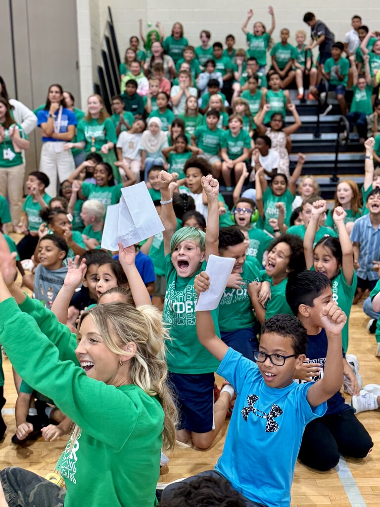 Students cheer and raise their hands during Winding Creek Elementary’s House Assembly in the school.
