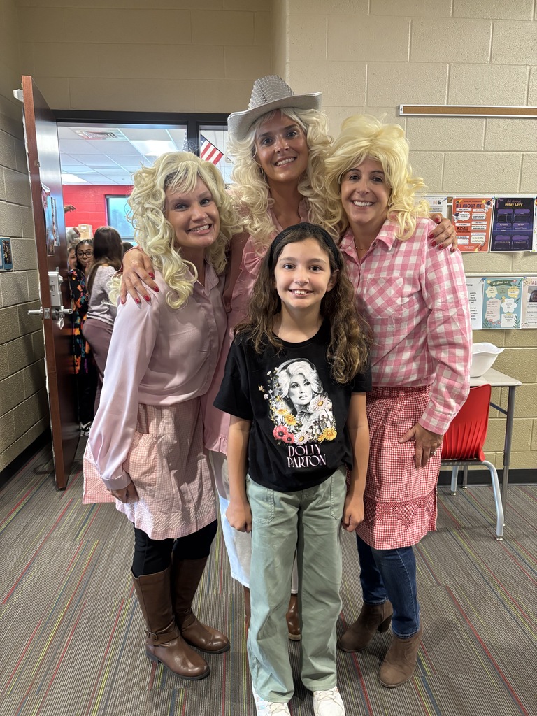 Winding Creek Elementary administrators and a student pose together in Dolly Parton-inspired outfits.