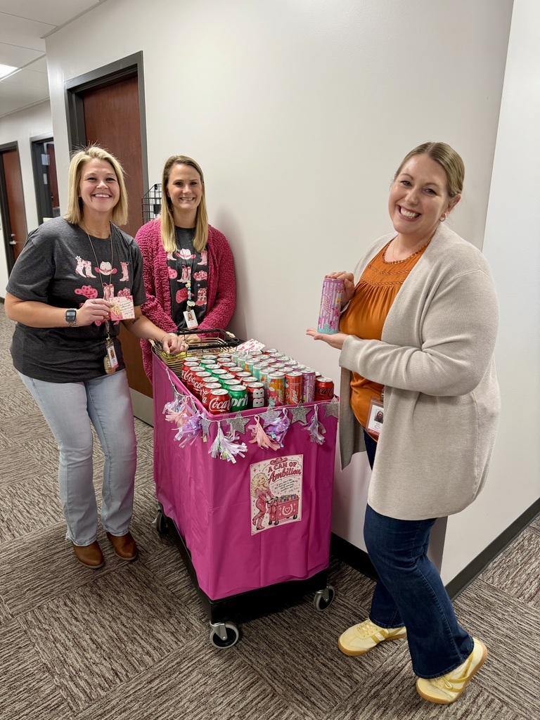 District offices employees posing with a cart full of goodies on 9-2-5 day, channeling Dolly Parton.