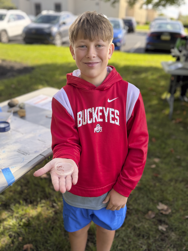 CV fifth-grade student holds a petri dish with a freshwater worm in it.