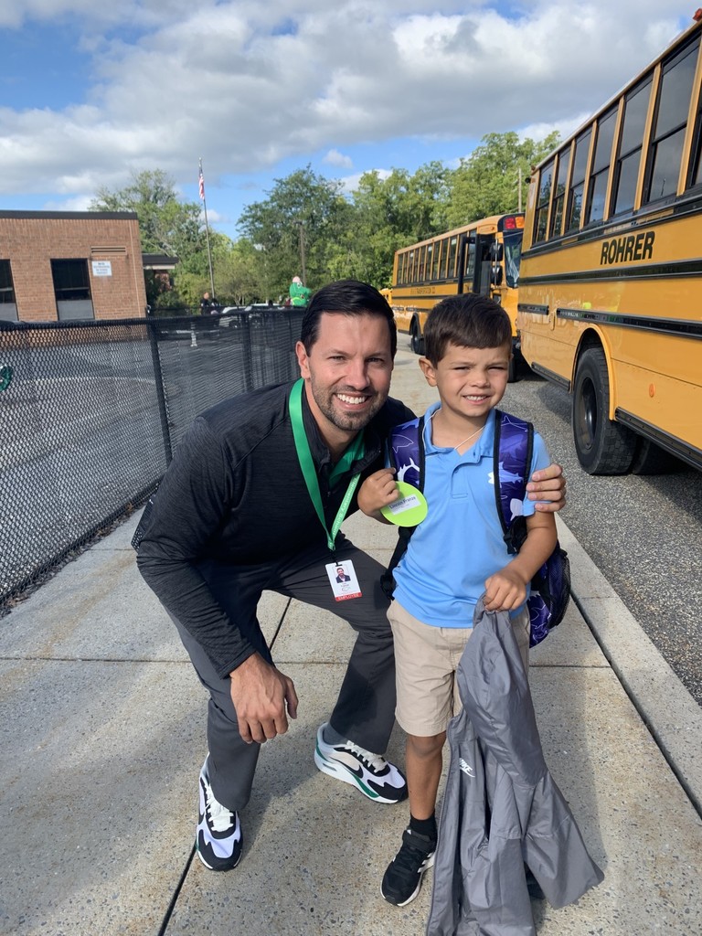 Principal with a student getting off the bus